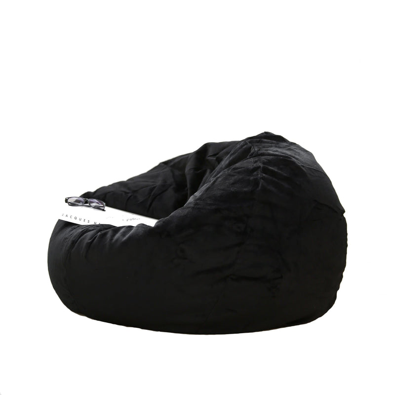 white coffee table book resting on a black fur bean bag on a white background