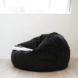 white coffee table book resting on a black fur bean bag on a white background