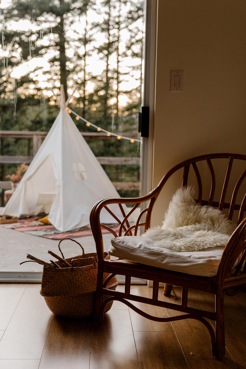 teepee tent outside on the balcony with an indian rug underneath it.