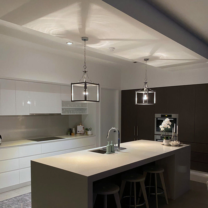 box pendant light in a white kitchen at night time with the lights on