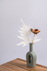 sage ceramic vase on a wooden shelf with dried flowers