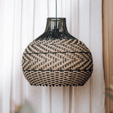 black rattan pendant light with natural accents on a white background