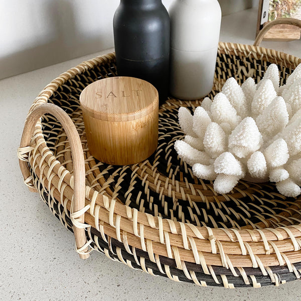 coral and salt on a large round rattan tray with handles
