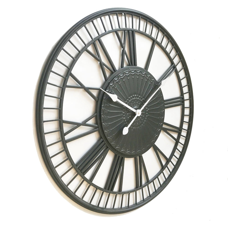 large metal wall clock with white hands on a white background