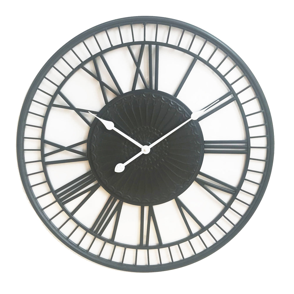 large metal wall clock with white hands on a white background