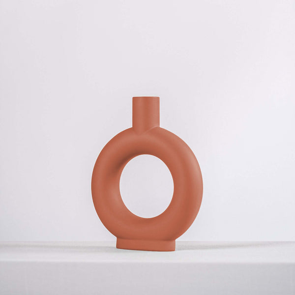 modern terracotta ceramic vase on a white shelf