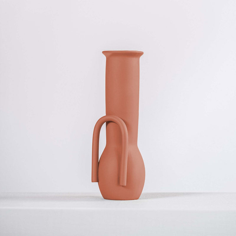 Terracotta ceramic vase on a white shelf