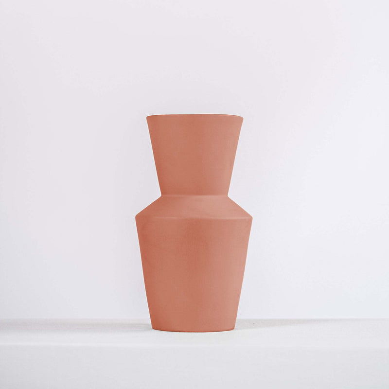 modern terracotta ceramic vase on a white shelf
