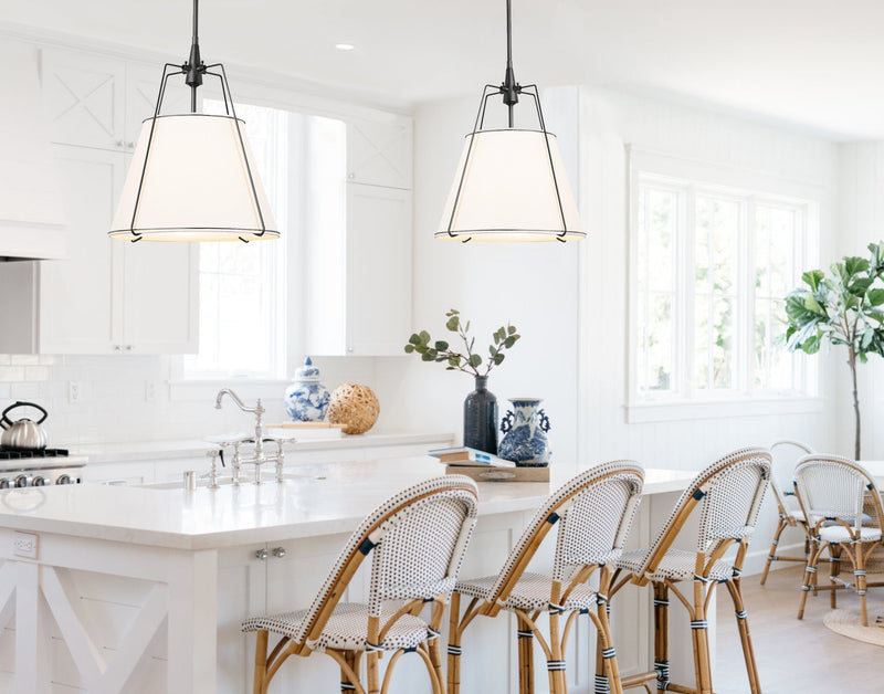 drum pendant light with black hardware in a white kitchen with rattan bar stools
