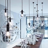 round glass pendant light with pearl black hardware hanging at different lengths