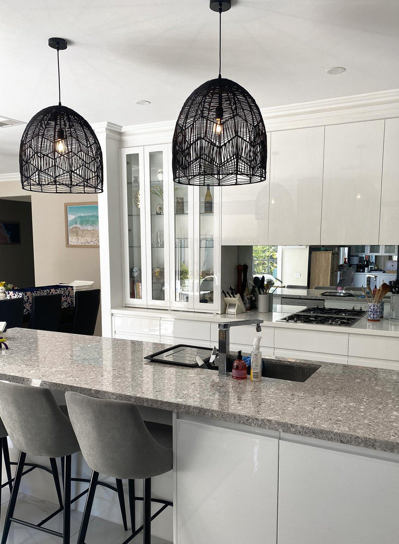 black rattan pendant light in a modern white kitchen with a stone bench top