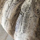 closeup of a large plush fur beanbag on a wooden floor