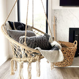 natural rope hanging macrame hammock chair with cushions and a cosy blanket