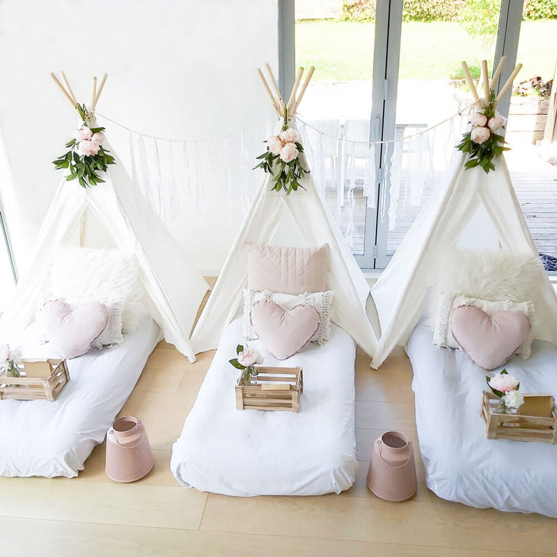 teepee tent birthday party scene with beds and flowers