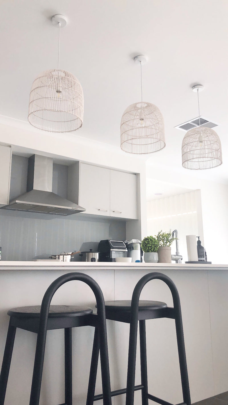 35cm white rattan pendant light in a modern white kitchen with black bar stools
